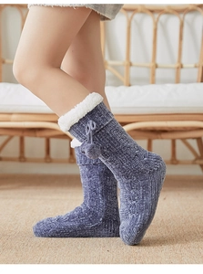 Detail of navy knit thermal floor socks with plush cuffs and pom-pom decorations