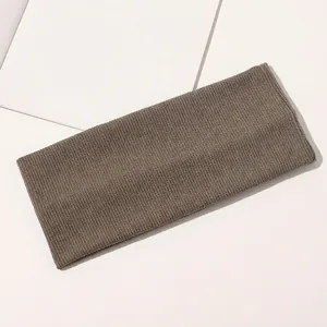 Detailed macro shot of coffee brown ribbed knit headband with elastic texture and soft fabric