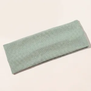 Macro detail of mint green ribbed knit yoga headband fabric showing texture and elasticity