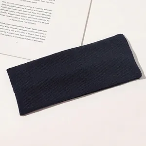 Detailed view of dark blue ribbed knitted headband on a minimalist background
