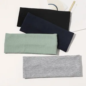 Close-up of four ribbed knit headbands in black, navy, sage green, and light gray colors