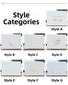 Detailed view of white greeting cards with gold foil patterns and festive messages