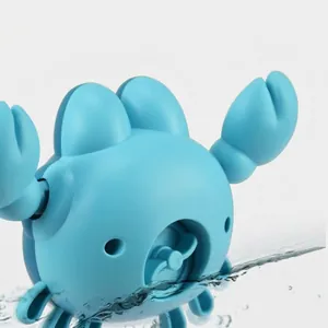 Blue wind-up crab water toy for babies, floating on water surface in a top-down view
