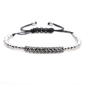 Macro detail of men's braided rope bracelet with silver beads and black zircon bar