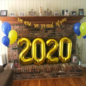 Graduation party decor set with 2020 gold balloons and We Are So Proud of You banner