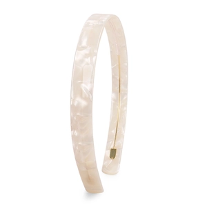 Macro shot of beige tortoiseshell headband texture with hidden gold metal inner wire