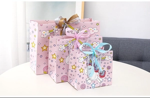 Three sizes of pink unicorn gift bags with cartoon patterns and ribbon bow closures