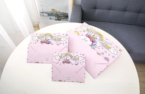 Three sizes of pink unicorn gift bags with handles on a white table background
