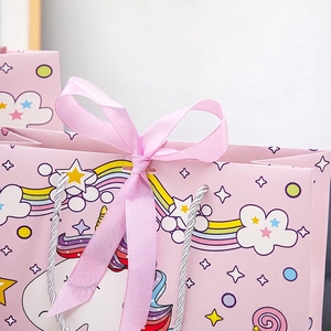 Pink unicorn paper gift bag with cute rainbow pattern and satin ribbon bow handle