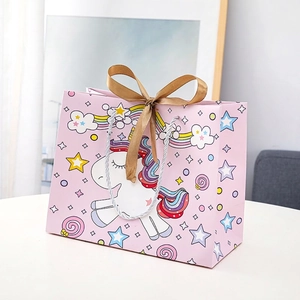 Pink unicorn gift paper bag with golden satin bow and rainbow stars patterns