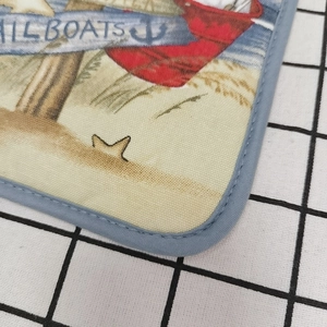 Close-up of thick cotton baking mat with sailboat print and reinforced edge stitching