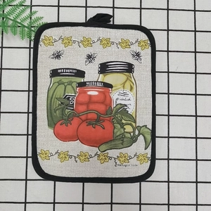 Detail of a thick cotton kitchen heat mat featuring vintage vegetable garden prints