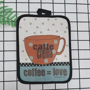 Close-up of thick cotton kitchen heat pad with coffee art and hanging loop detail