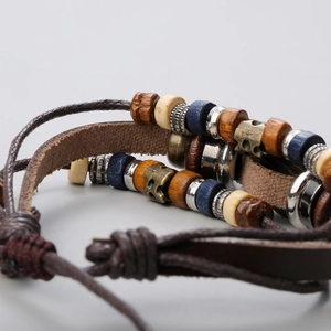 Macro view of multi-layer leather bracelet with turquoise and wooden beads in punk style