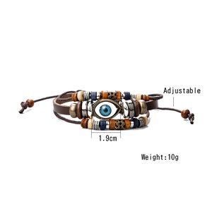 Close-up of leather bracelet with blue evil eye, wooden beads, and adjustable cord