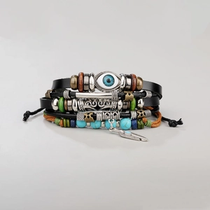 Detail of multi-layer leather bracelet with blue evil eye bead and silver feather charm