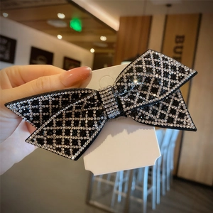 Handcrafted black bow hair clip with sparkling white rhinestones in a grid pattern