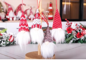 Detail of handmade knit Christmas gnome ornaments with red felt hats and soft faux fur