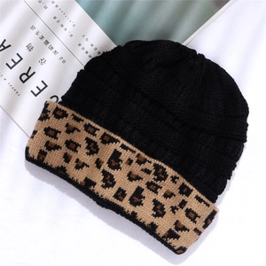 Macro detail of acrylic beanie with black knit texture and leopard print fold-up cuff