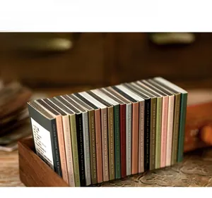 Detail of vintage floral scrapbooking paper packs in matchbox-style packaging on wood