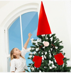 Macro view of a girl touching a large red gnome hat and mittens for Christmas tree decor