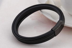 Close-up of multilayer braided black leather bracelet with matte metal magnetic clasp