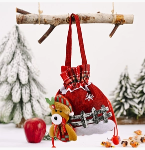 Close-up of a red burlap Christmas gift bag with a cute 3D bear doll and drawstring