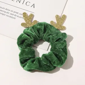 Detail of forest green velvet Christmas scrunchie with sparkling gold sequin reindeer antlers