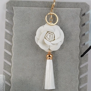 Elegant white camellia flower keychain with golden hardware and fringe tassel detail