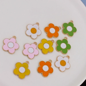 Detailed view of colorful enamel sunflower pendants with gold metal rings for DIY jewelry