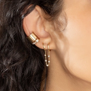 Close-up of gold ear cuff and linked chain hoop earring with sparkling white diamonds