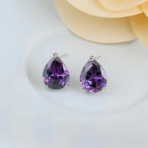 Close-up of teardrop purple zircon earrings with classic silver claw setting design