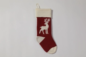 Close-up of red and white knitted Christmas stocking featuring a white reindeer pattern