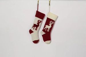 Detail of red and cream knitted Christmas stockings with reindeer patterns and hanging loops