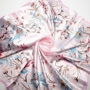Macro shot of silk texture with bohemian floral pattern on light pink large square scarf
