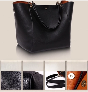 Detail of black PU tote bag showing pebbled texture, orange lining, and magnetic closure