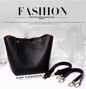 Detail of black pebbled leather bucket bag with orange interior and gold hardware