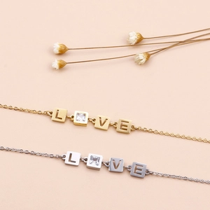 Adjustable LOVE letter bracelet in gold and silver steel with cubic zirconia charms
