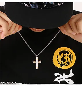 Vue détaillée du collier croix bicolore pour homme avec design industriel en acier