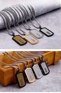 Detail of dog tag pendants in black, gold, and silver with zircon stones and bead chains