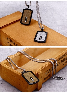 Macro view of gold and silver tag necklaces with black border and rhinestone inlay