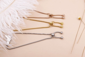 Detail of adjustable box chain bracelets in rose gold, gold, and silver finishes