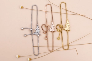 Close-up of adjustable bead chain bracelets with little prince charms in three metal colors