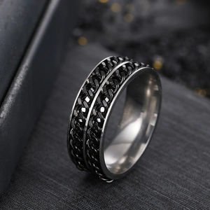 Macro shot of silver titanium steel spinner ring with dual black chains on dark background