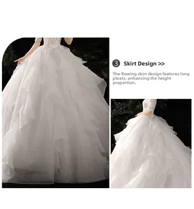 Close-up of white off-shoulder bridal gown featuring layered ruffle tulle and lace embroidery