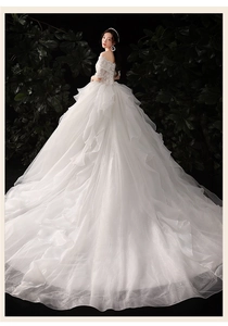 Detail of off-shoulder wedding dress with bead embroidery and long trailing train