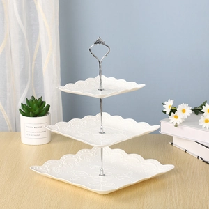 Soporte cuadrado blanco para postres de tres niveles con relieve y asa de metal plata