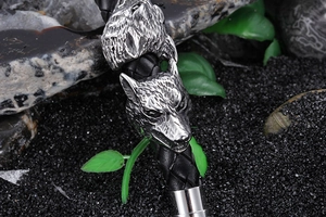 Detailed macro view of vintage silver wolf head engraving on black braided leather bracelet