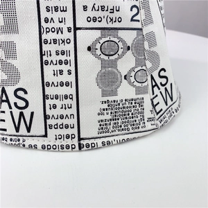 White canvas bucket hat featuring vintage black newspaper print with a cotton twill texture