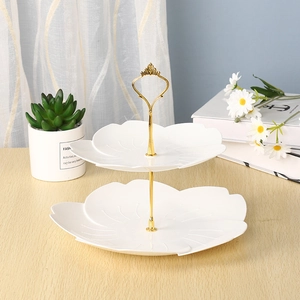 Elegant 2-tier white petal-shaped fruit tray with golden metal stand on wooden table